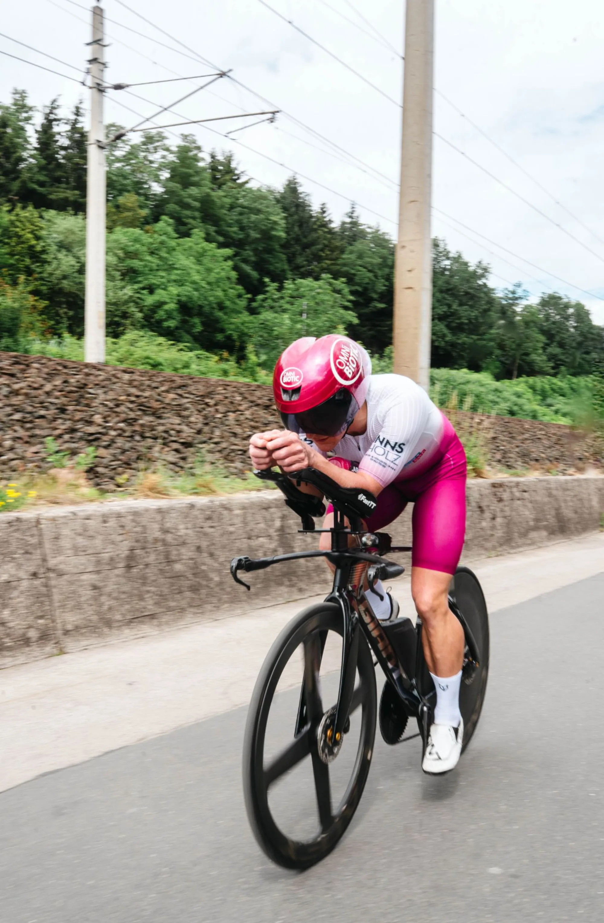Athlete in a magenta custom suit on the time trial bike